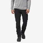 Man wearing black Patagonia Point Peak Trail Pants with gray shirt and hiking boots