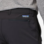 Close-up of black Patagonia trail pants showing waistband, pocket, and brand logo