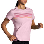 Woman wearing Brooks Distance short sleeve running shirt in quartz pink with gradient stripes