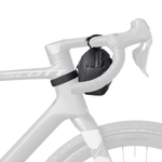 Black Syncros handlebar bag mounted on white bicycle handlebars against white background