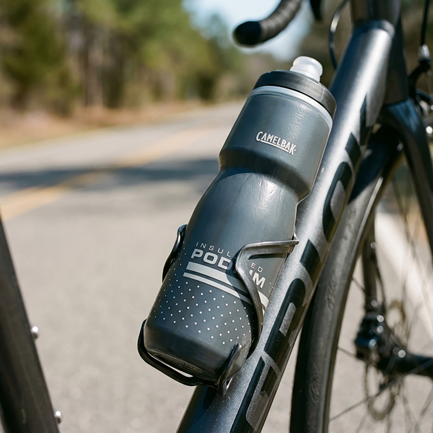 CamelBak Podium insulated water bottle mounted on bicycle frame in outdoor setting