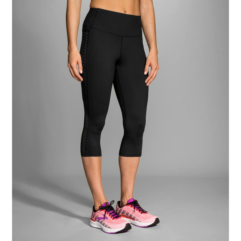 Woman wearing black Brooks Greenlight capri leggings with mesh panel details