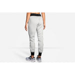 Woman wearing gray Brooks Fremont joggers with black cuffs, back view