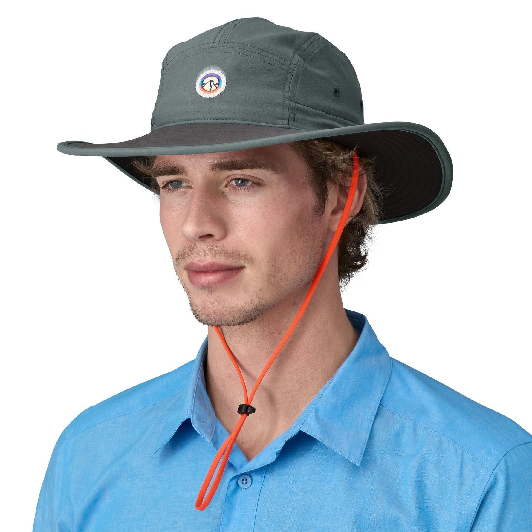 Man wearing Patagonia Quandary Brimmer hat in sage green with orange chin strap