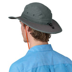 Man wearing Patagonia Quandary Brimmer hat in green with orange chin strap