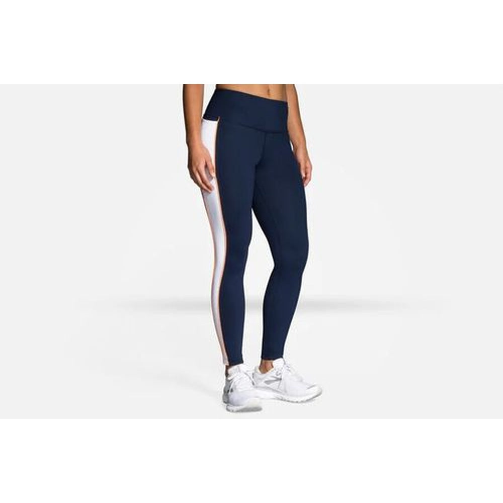 Woman wearing Brooks Greenlight navy leggings with white side panels and white sneakers