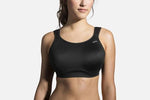 Woman wearing black Brooks Maia sports bra on clean studio background