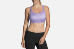 Woman wearing Brooks Fiona Sport Bra in lilac with black leggings