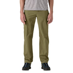 Man wearing Patagonia Quandary pants in tent green against white background
