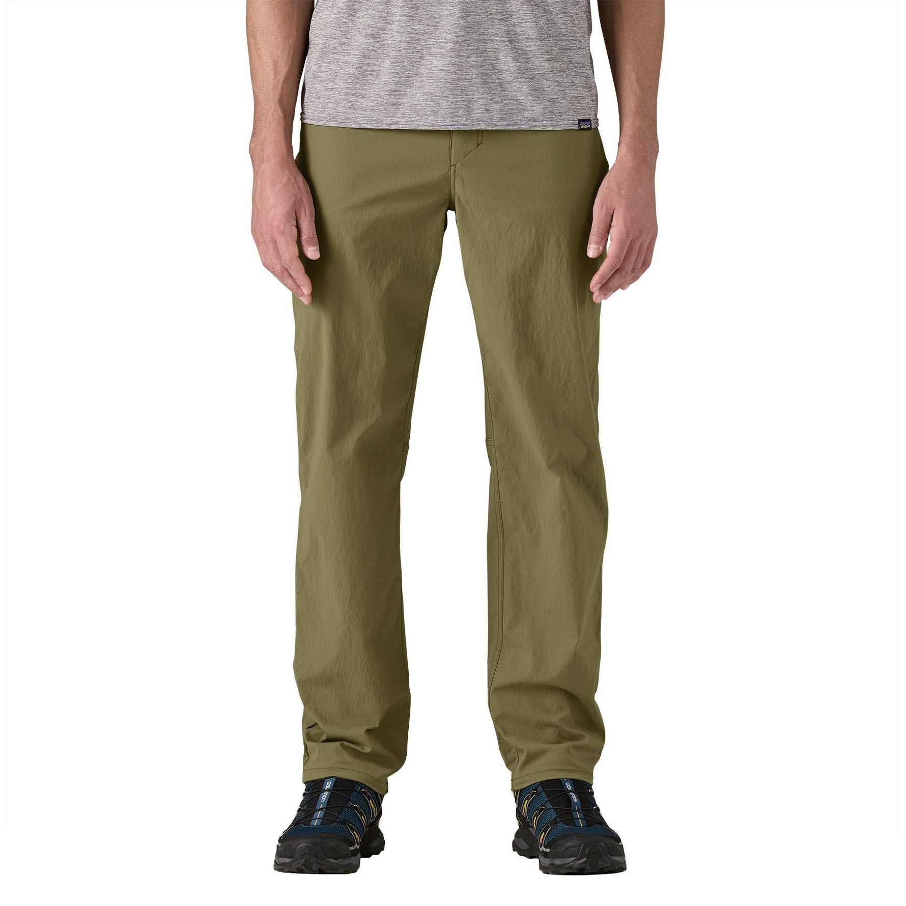 Man wearing Patagonia Quandary pants in tent green against white background