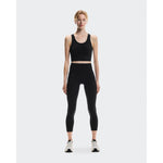 Woman wearing black On Studio 7/8 tights with matching crop top