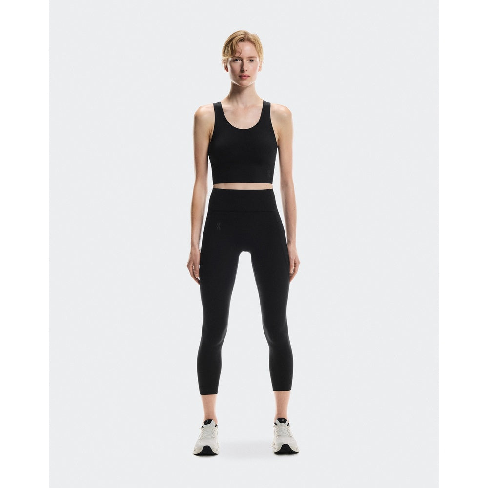 Woman wearing black On Studio 7/8 tights with matching crop top