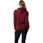 Woman wearing burgundy hooded pullover fleece, back view against white background