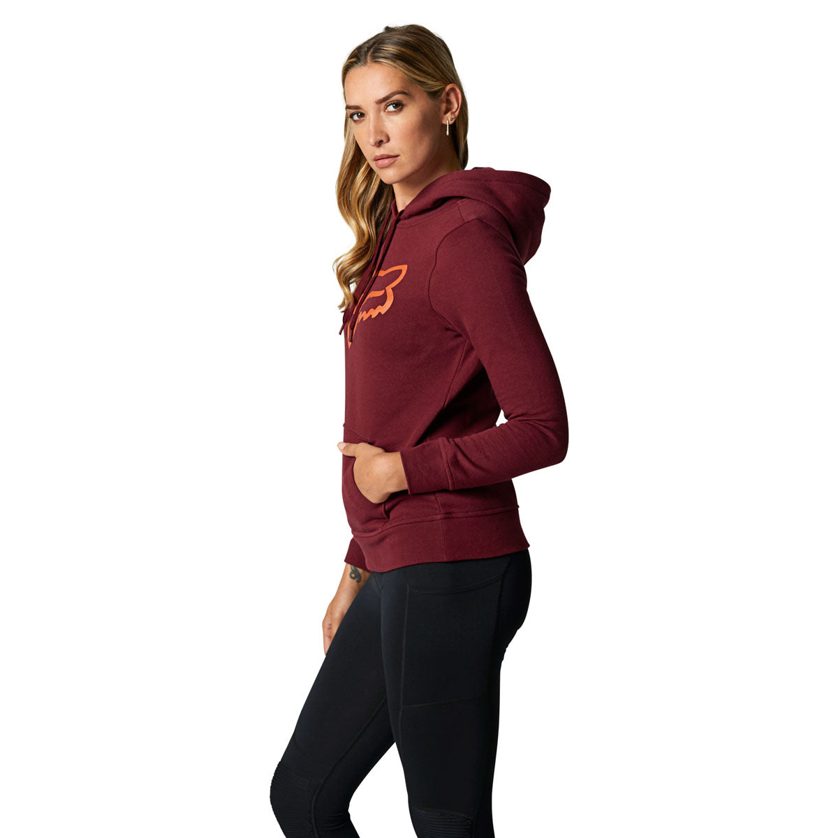 Woman wearing Fox Racing burgundy pullover hoodie with orange logo on white background