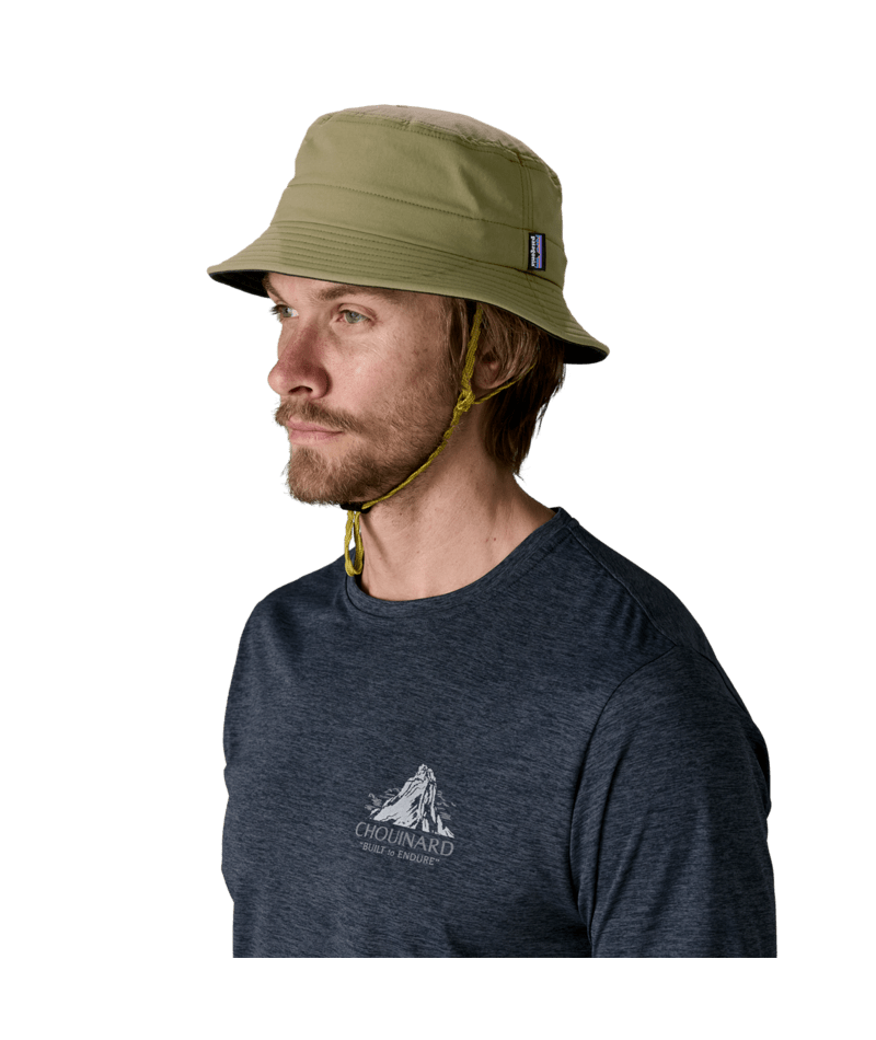 Man wearing Patagonia Surf Brimmer Hat in basin green with chin strap