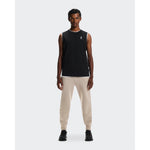 Man wearing On Focus Tech Sweatpants in desert/beige with black tank top