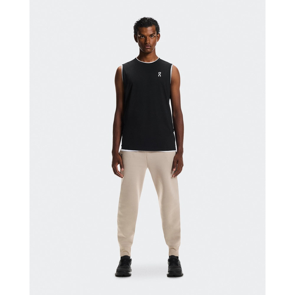 Man wearing On Focus Tech Sweatpants in desert/beige with black tank top