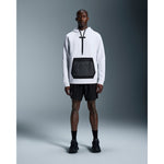 Man wearing black On 7 inch Core Shorts with white hoodie in studio setting
