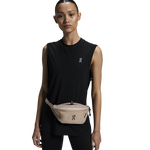 Woman wearing On Waist Pack 2L Lite in sand color around waist with black athletic wear