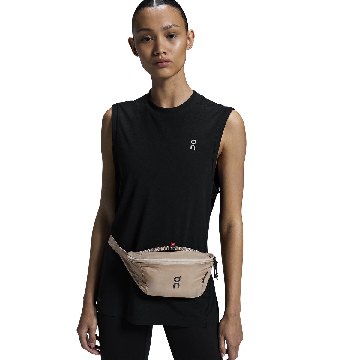 Woman wearing On Waist Pack 2L Lite in sand color around waist with black athletic wear