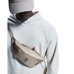 On Waist Pack 2L Lite in sand color worn across chest by model
