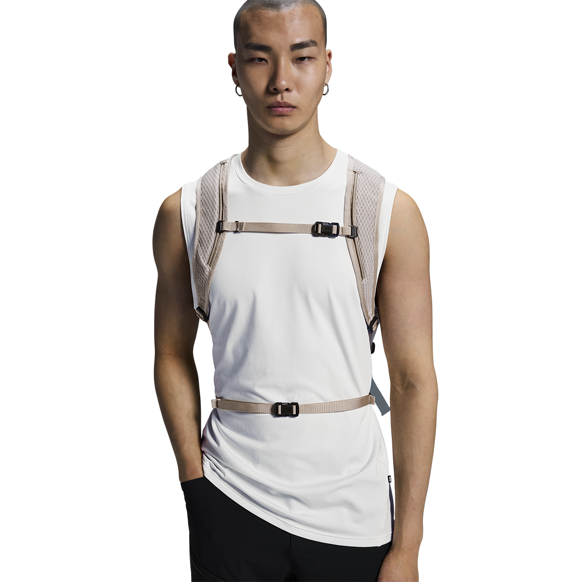 Male model wearing On Speed Pack 18L Lite backpack in cream with chest straps