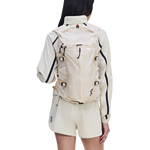 Woman wearing On Speed Pack 18L Lite backpack in cream color, rear view