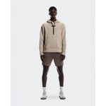 Man wearing beige On Focus Tech Hoodie with matching shorts and white sneakers