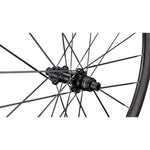 Close-up of Specialized Roval bicycle wheel hub with black spokes against white background
