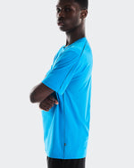 Man wearing bright blue On Focus-T athletic shirt against clean white background