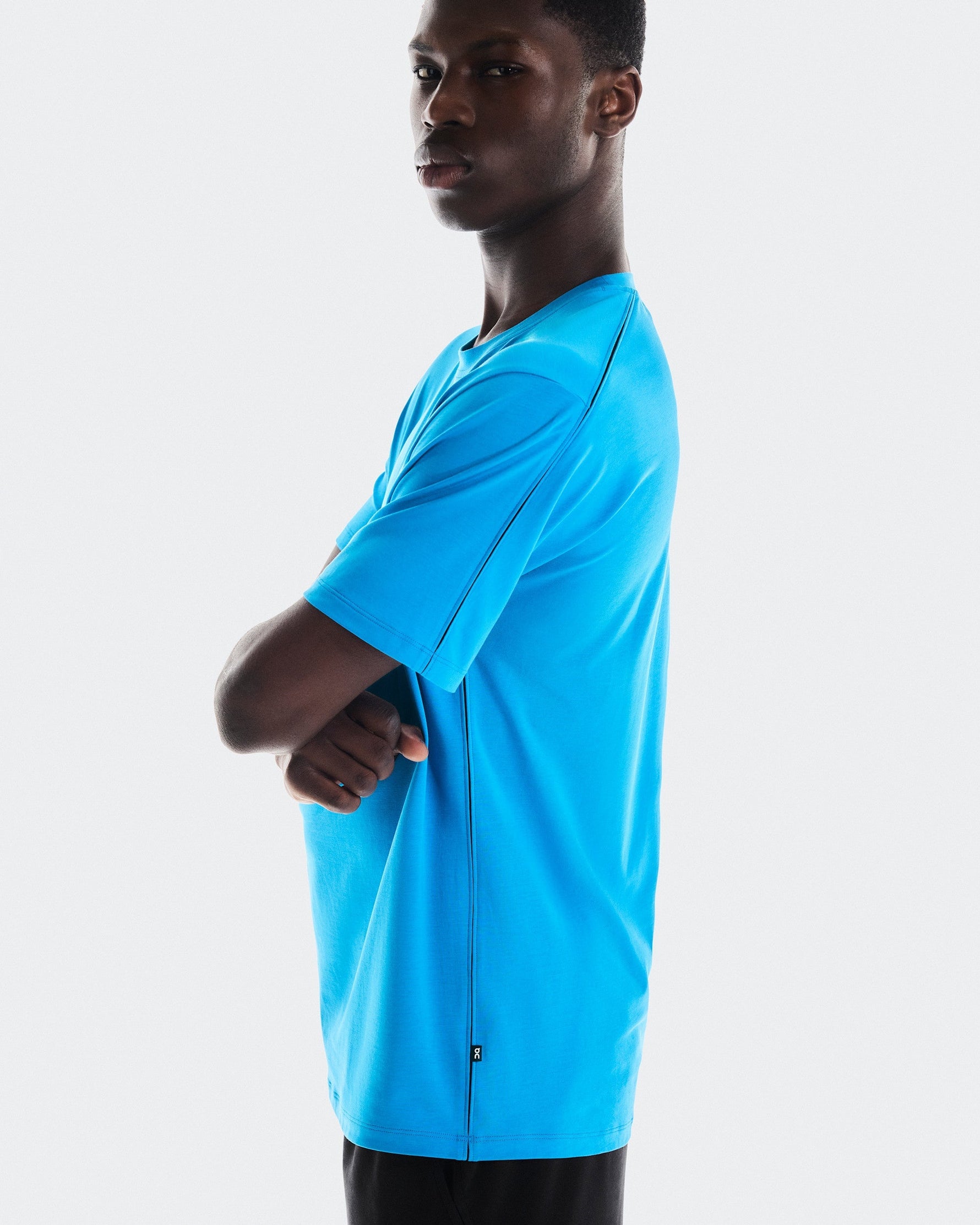 Man wearing bright blue On Focus-T athletic shirt against clean white background