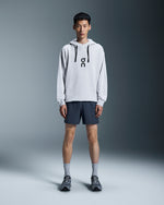 Man wearing On 5 inch Core Shorts in navy blue with grey hoodie