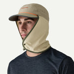 Man wearing Patagonia Caped Merganzer Hat in tan with neck protection and orange trim