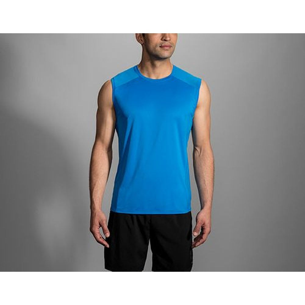 Man wearing blue Brooks sleeveless running singlet with black shorts on gray background