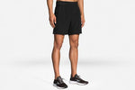 Man wearing black Brooks Sherpa 7-inch running shorts with athletic sneakers