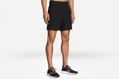 Man wearing black Brooks Sherpa 7-inch running shorts with athletic sneakers