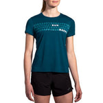 Brooks Distance Short Sleeve 2.0 in teal with Run Happy graphic print on female model