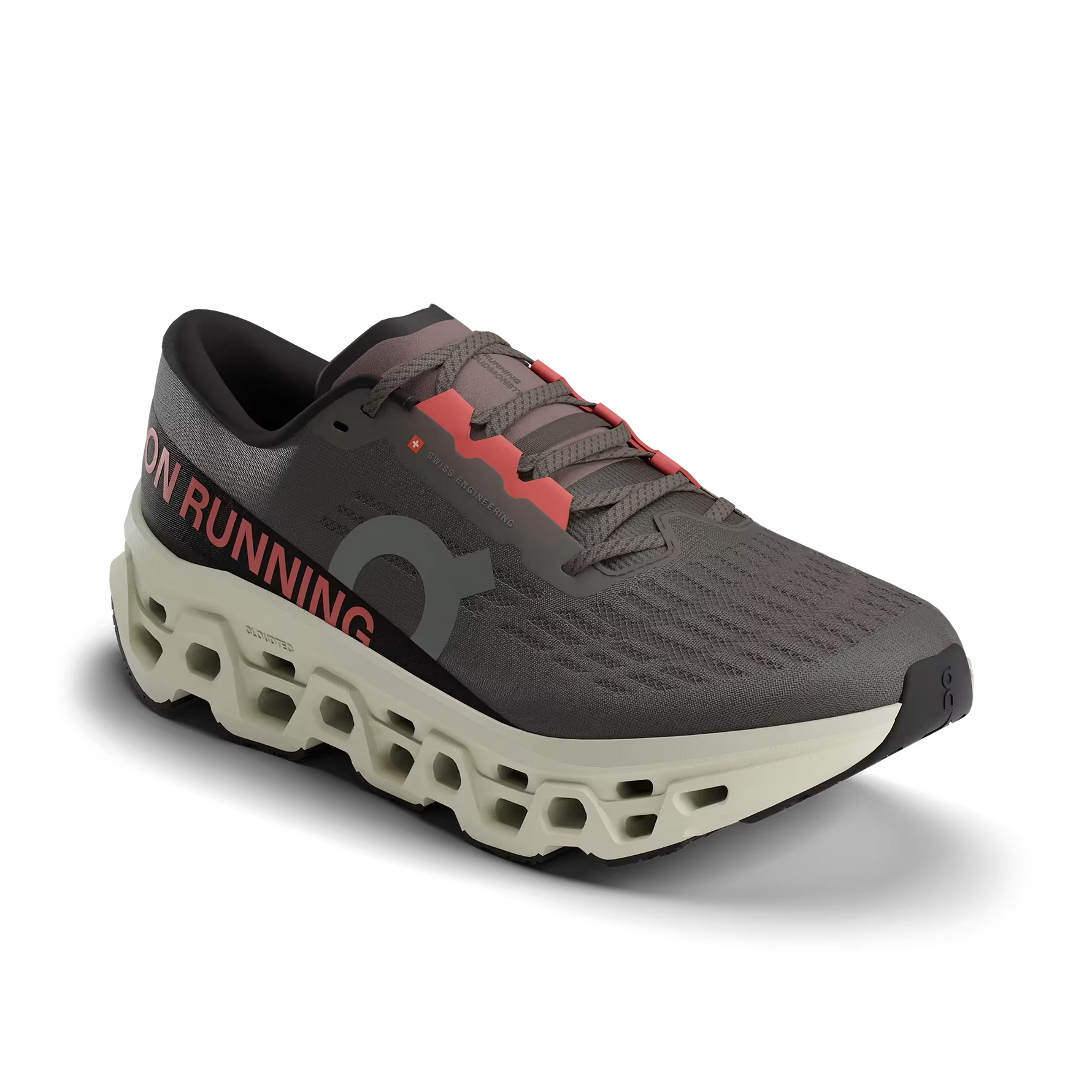 On Cloudmonster 3 running shoe in dark gray with coral accents and distinctive perforated sole