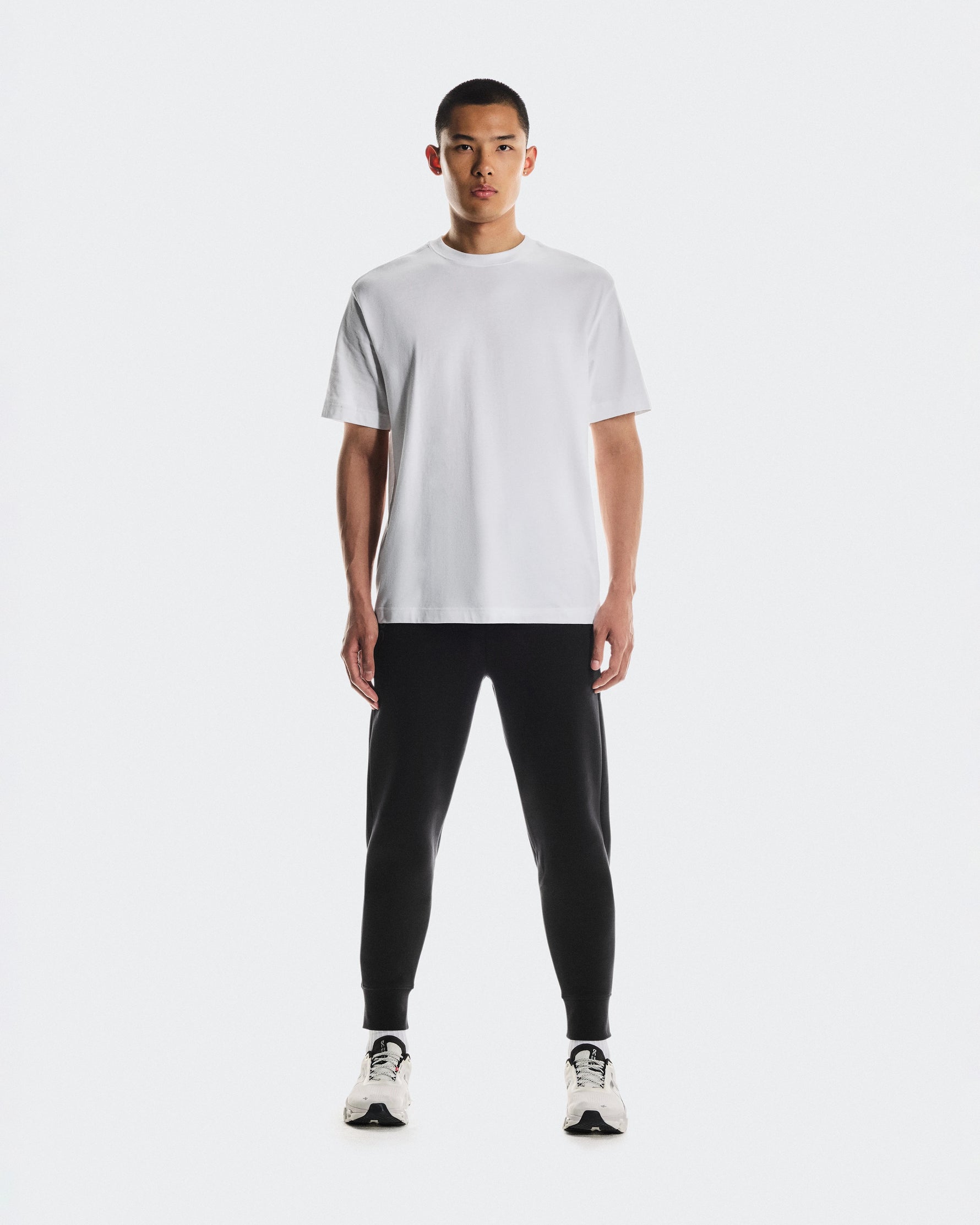 Man wearing black On Focus Tech Sweatpants with white t-shirt and sneakers