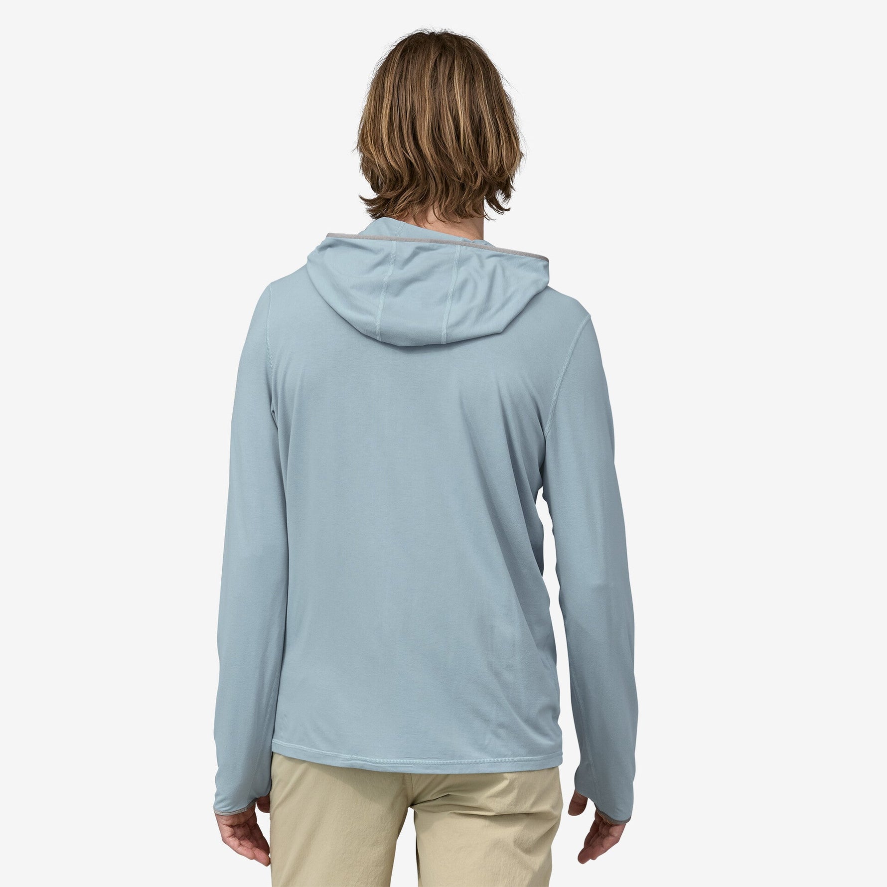 Back view of man wearing light blue hooded long-sleeve shirt with khaki pants
