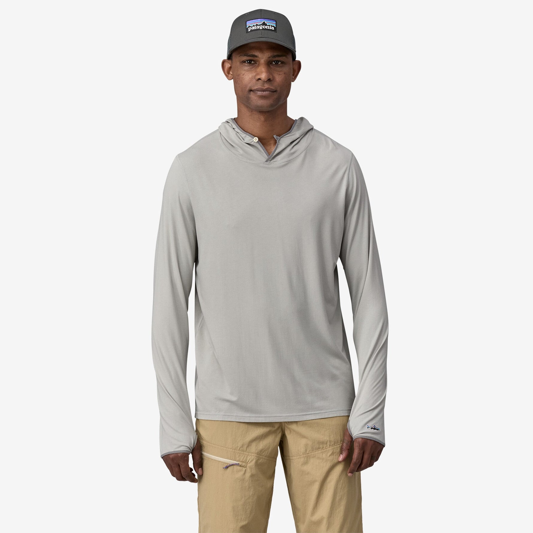 Man wearing Patagonia light green hooded long-sleeve shirt with tan pants and cap