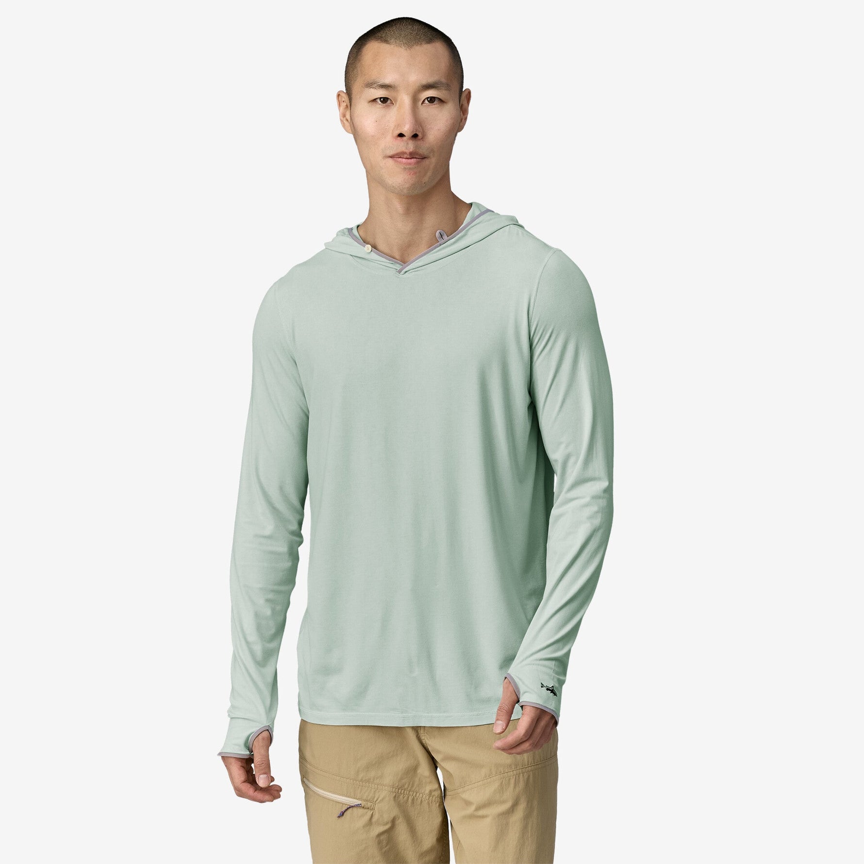 Man wearing light green hooded long-sleeve shirt with khaki pants