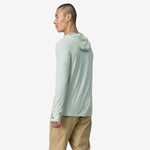 Man wearing Patagonia light green hooded long-sleeve shirt against white background