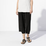Black Birkenstock Gizeh sandals worn by model in studio setting