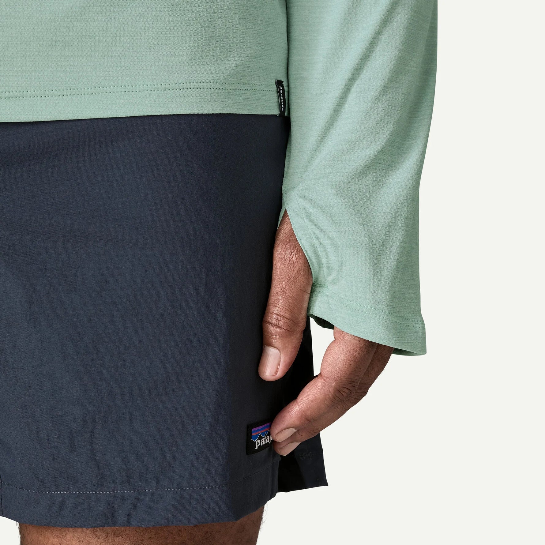 Patagonia sun hoody in mint green with navy shorts showing sleeve detail and fit