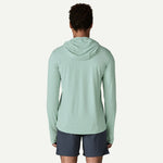 Back view of man wearing light green Patagonia hooded long sleeve shirt with navy shorts