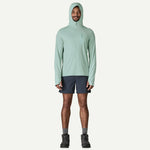 Man wearing sage green Patagonia hooded sun shirt with navy shorts