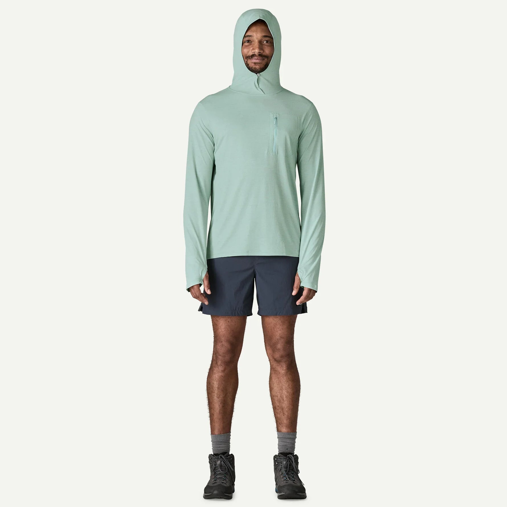 Man wearing sage green Patagonia hooded sun shirt with navy shorts