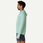 Man wearing mint green Patagonia sun hoody with hood, side profile view