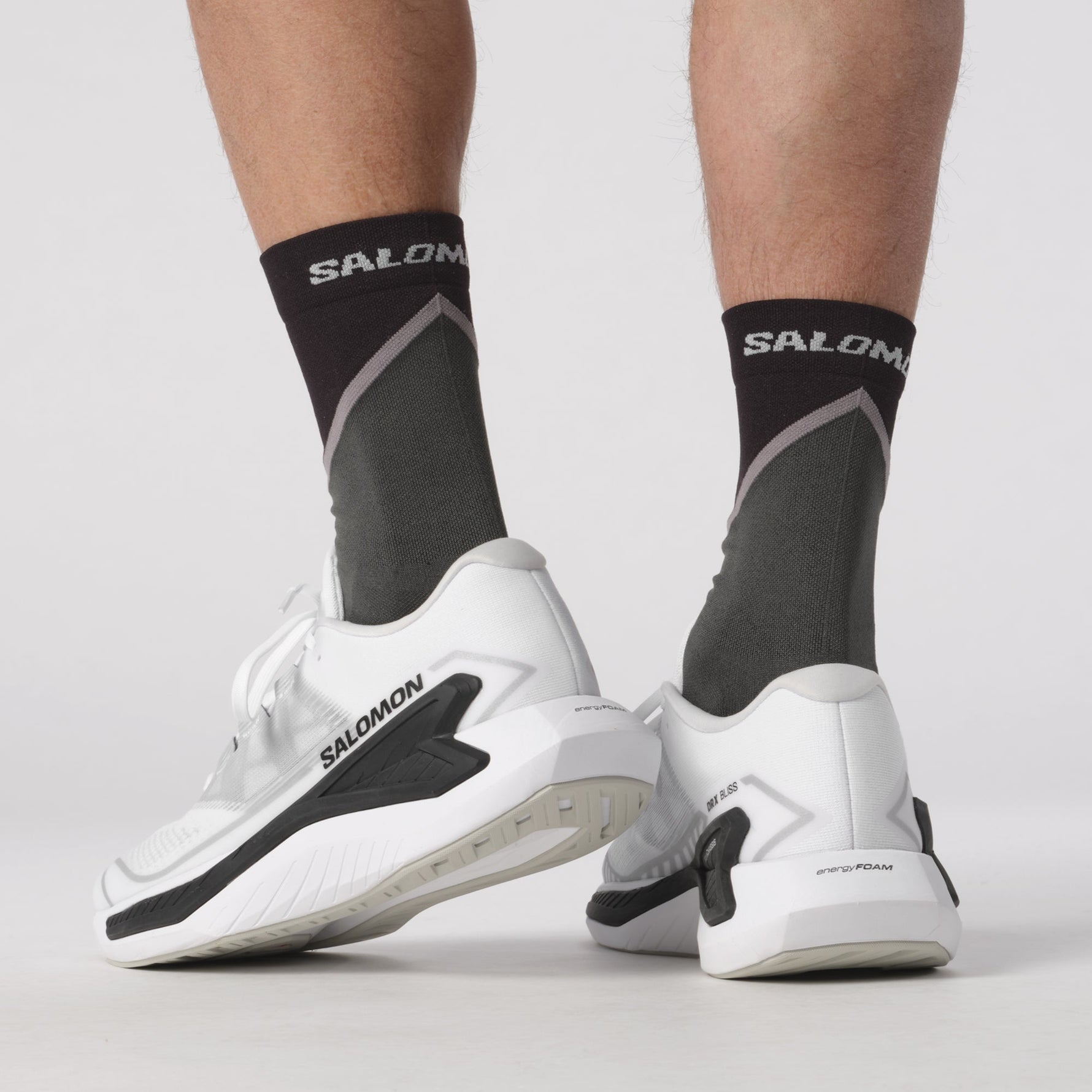 Salomon DRX Bliss running shoes in white with black accents on model's feet